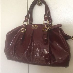 Coach burgundy bag comes with strap that can turn the bag into a crossbody